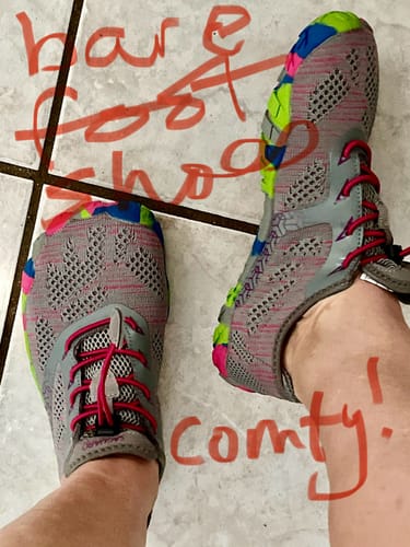 Reviewer's feet wearing the grey Smart II - Barefoot Shoes with colorful pink and green accents.