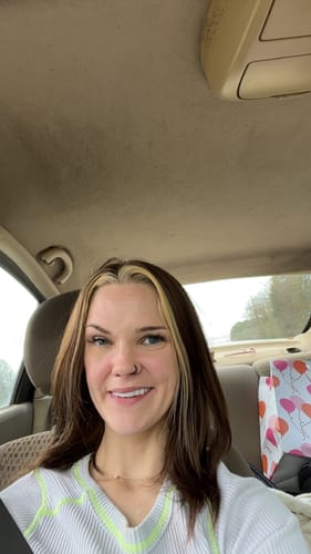Customer in a car, smiling to display her custom-made Pop On Veneers.