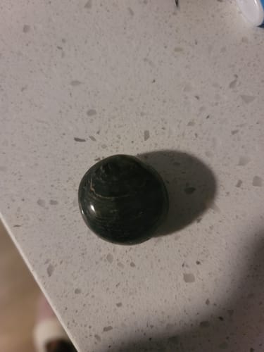 Customer's round, dark monthly crystal sitting on a countertop.