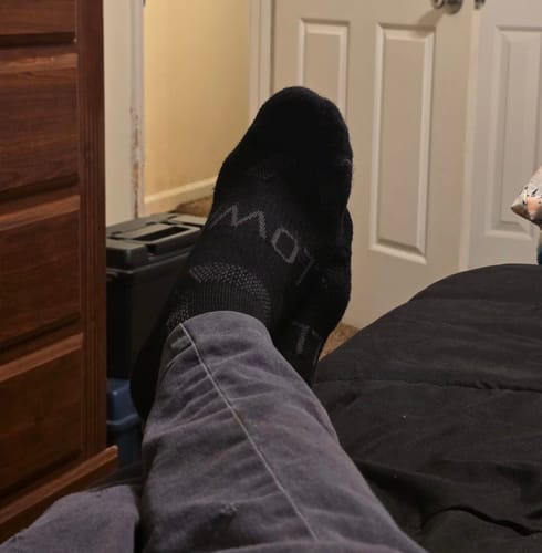 Close-up of a reviewer's foot wearing the black Men's Alpaca Socks, showing the fit.