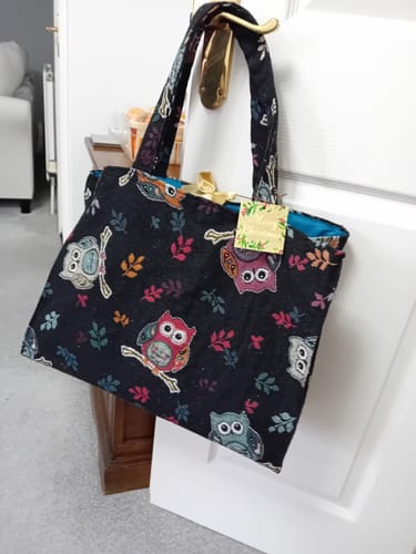 Customer's large shopping bag made from the heavy-duty Owl printed tapestry fabric, hanging on a door handle.