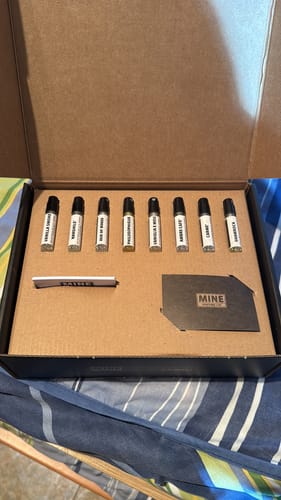 Recensore mostra il Set campioni dolci e calde nella sua scatola aperta con gli 8 campioni di profumo allineati.