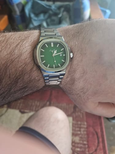 Customer's review photo showing the Lucky Fours® Caspian watch with a green face and silver band on a wrist.