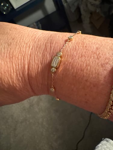 Close-up of a customer wearing the Doveggs elongated emerald moissanite bracelet on their wrist.
