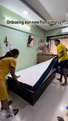 Customers placing their new Flo Mattress Ortho with a white top onto a dark bed frame.