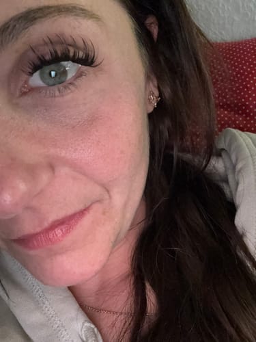 Kundin zeigt in einer Nahaufnahme ihre langen, vollen Wimpern nach der Anwendung des Starterkits.