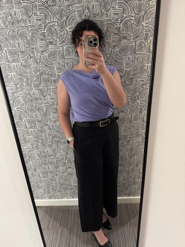 Customer's mirror selfie showing the fit of the black, wide-leg Elena Travel Culottes paired with a purple top and black shoes.