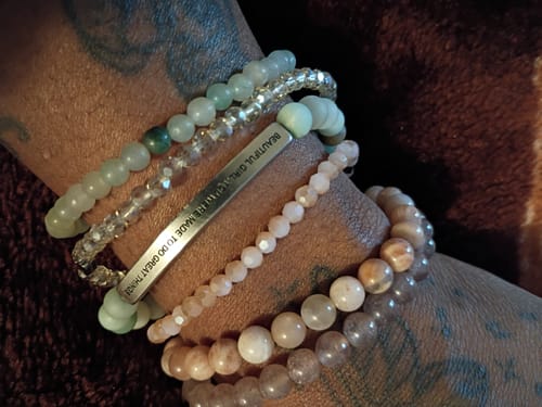 Customer's wrist with a stack of bracelets, highlighting the beaded Sunstone Stacker.
