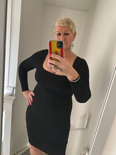 Reviewer taking a mirror selfie in the black Long Sleeve Midi Shapewear Dress.
