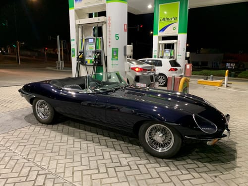 Customer's shiny classic E-Type car at a gas station, showing the glossy results of the waterless wash.