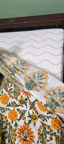 Customer's Flo Mattress Ortho on a bed, showing its white cover with a wavy beige pattern.