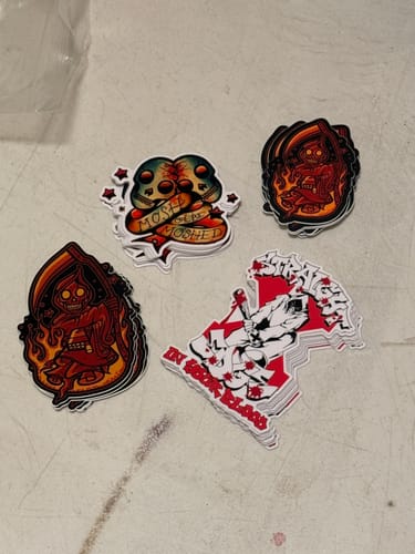 Reviewer's four different stacks of colorful custom vinyl stickers with various graphic illustrations.