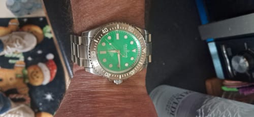 Customer's Oceaneva Deep Marine Explorer III watch with a green dial and stainless steel band, shown on their wrist.