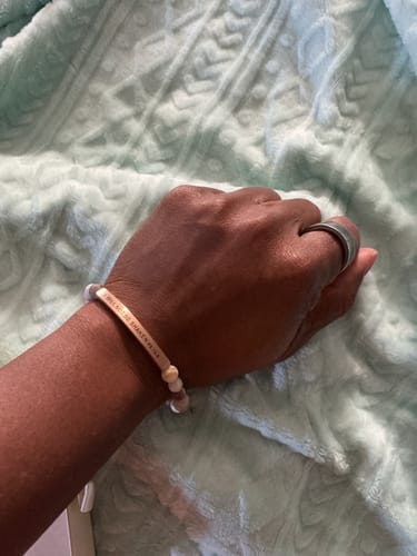 Reviewer showing the 'I WILL NOT BE SHAKEN' beaded bracelet on their wrist.