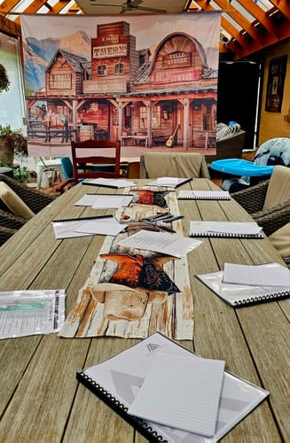 Customer's table set for the Wild West Cowboy Murder Mystery game, with a western town backdrop.