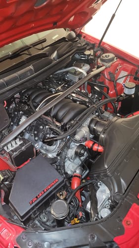 Customer's installed Motion Raceworks Coolant Crossover Steam Kit on an LS engine in a red car.