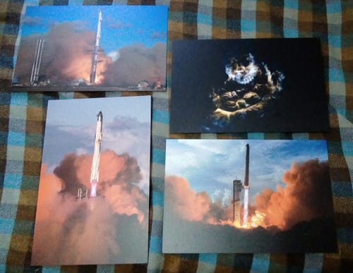 Customer's collection of four different Starship prints showing rocket launches, laid out on a plaid surface.