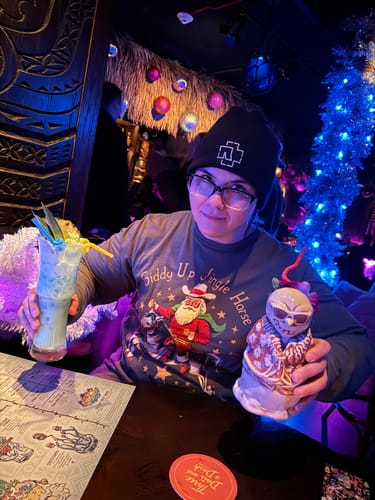 Reviewer wearing the green Giddy Up Jingle Horse Long Sleeve Tee in a festive bar.