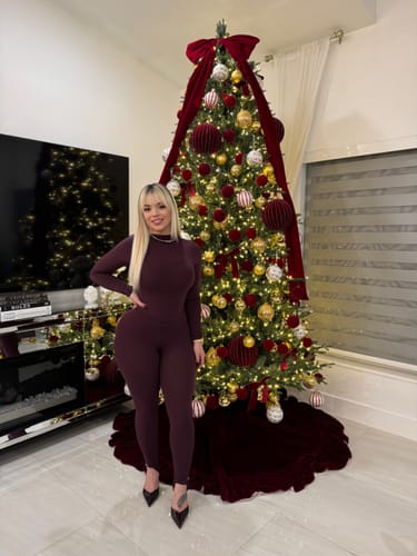 Customer showing a full-body view of the dark Naked Stirrup Legging set in front of a tree.