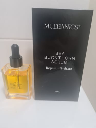 Reviewer's Sea Buckthorn Serum in a clear glass bottle next to its black packaging box.