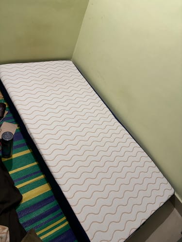 Customer's Flo Mattress Ergo with a white, wavy-patterned top, shown on the floor of a room.