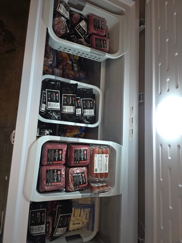 Customer's upright freezer fully stocked with their new Quarter Beef Bundle, organized in drawers.