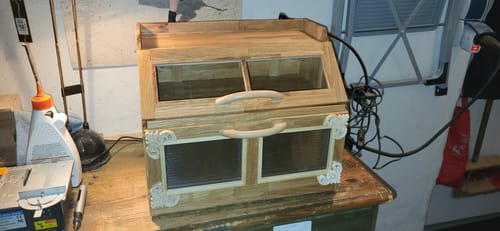 Ein Kunde zeigt eine fertige, selbstgebaute Holzvitrine, die aus den Easy-Sticks aus Eiche hergestellt wurde.