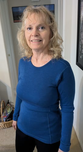 Reviewer standing in a hallway wearing the Hannah Long Sleeve Top in Nightfall blue.