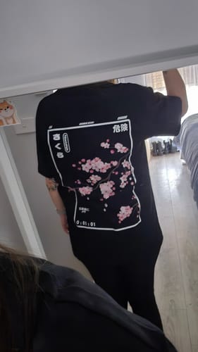 Reviewer from behind wearing the black Cherry Blossom T-Shirt, showing the large cherry blossom back print.