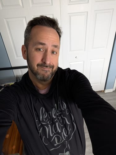 Reviewer taking a selfie to show the fit of the black Legends Never Die Performance Hoodie.