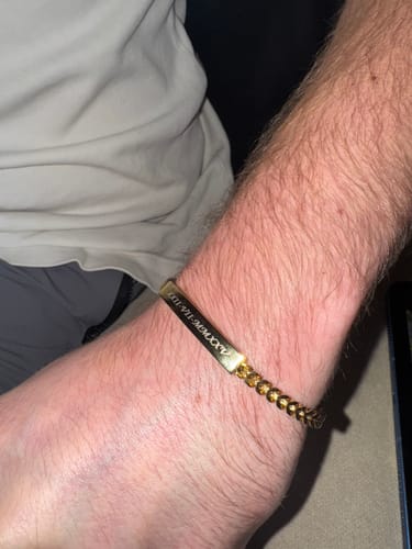 Reviewer wearing the gold Franco Link ID Bracelet, showing the custom Roman numeral engraving on their wrist.