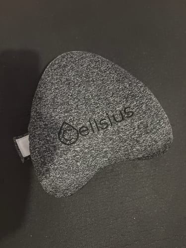 Un client montre la housse grise chiné pour le coussin genoux Cellsius, posée à plat.