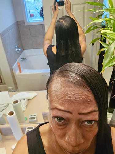 Customer's mirror selfie showing an improved hairline and long hair after using Rennora Hair Growth Serum.
