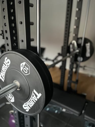 Nahaufnahme der R8-Smith Multipresse eines Kunden, mit einer Hantelscheibe auf der schwarzen Stange.