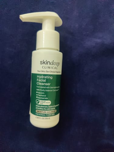 Customer's white pump bottle of skindeep CLINICAL Hydrating Facial Cleanser on a blue surface.