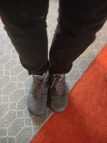 Asiakkaan jalassa harmaat Vaistoa Uoma 3 Talvi -kengät sisätiloissa.