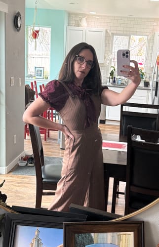Reviewer taking a mirror selfie wearing the red and striped 1930s jumpsuit, showing its mock two-piece style.