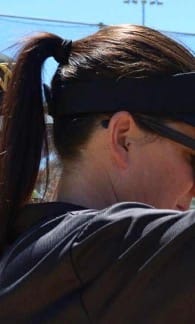 A reviewer from behind with dark, healthy-looking hair tied in a ponytail after using the hair treatment.