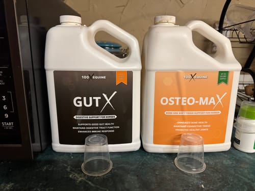 Reviewer's jugs of Gut X and Osteo-Max supplements side-by-side on a counter.