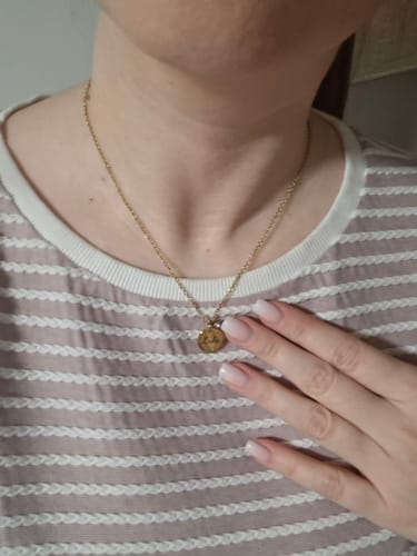 Reviewer wearing the delicate, gold Name Birthstone Necklace with a round pendant against their chest.