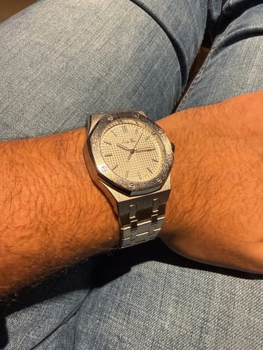 Customer's close-up of their silver Lucky Fours Oceanus watch on their wrist against a denim background.