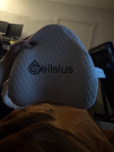 Cliente tenant le coussin pour genoux Cellsius avec sa housse blanche et texturée dans sa main.