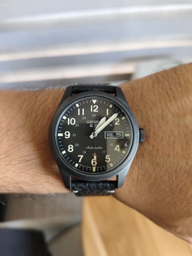 Cliente mostrando en su muñeca el reloj Seiko 5 Automático con esfera negra y números blancos visibles.
