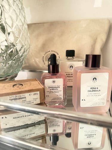 Reviewer's Barrier Protection Routine products, including pink serum and lotion, arranged on a mirrored shelf.