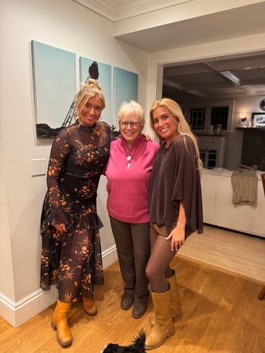 Reviewer wearing the pink Collins Half Zip Sweater while posing indoors with two other people.