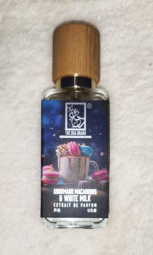 Customer's bottle of Gourmand Macaroons & White Milk perfume with a wooden cap, resting on a soft white surface.