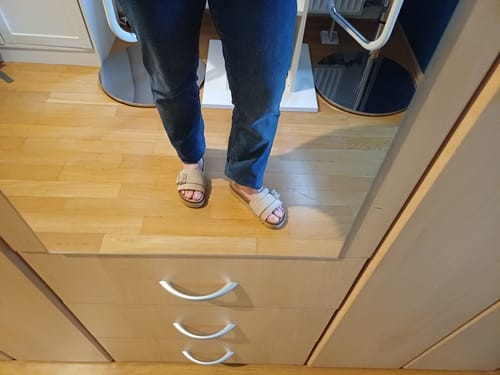 Reviewer wearing the beige Joyce sandals with blue jeans, seen in a mirror.