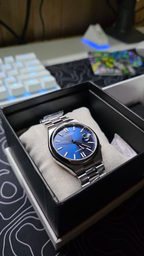 El reloj Citizen Tsuyosa del cliente con su esfera azul brillante, visto dentro de su caja de presentación.