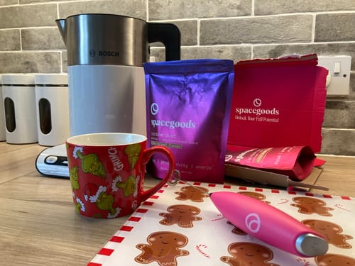 Customer's rainbow dust pouch and delivery box on a counter with a kettle and a festive mug.