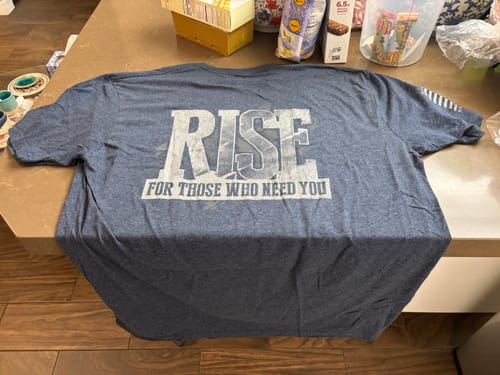 Customer's blue T.V.P. Elite Membership t-shirt with 'RISE FOR THOSE WHO NEED YOU' printed on the back.